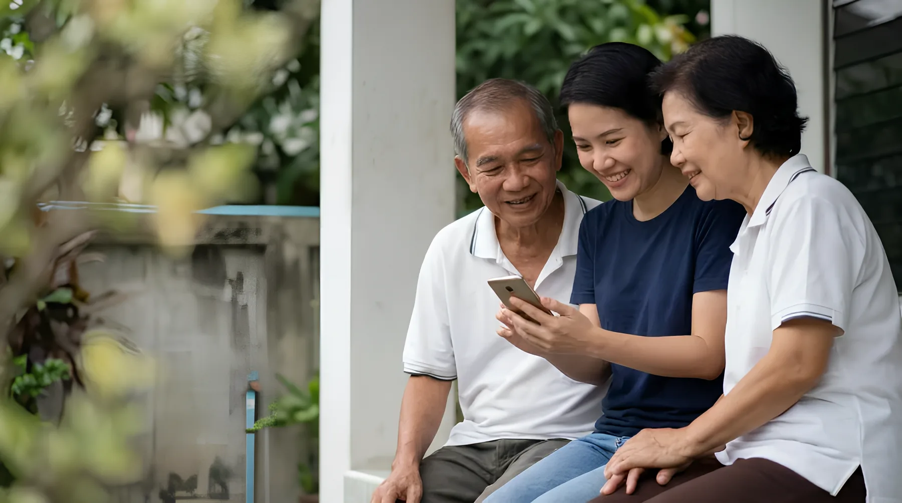 ผู้สูงอายุนั่งดูมือถือกับลูกหลาน